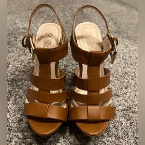 Woman’s dark tan wedges